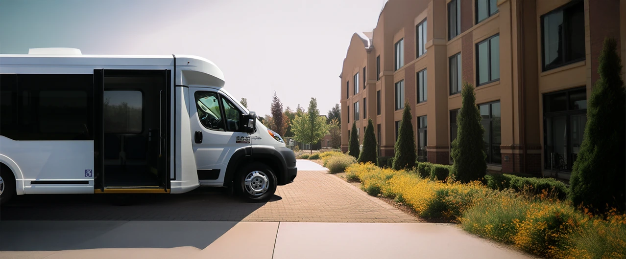 white shuttle accessible van parked in front of a retirement home