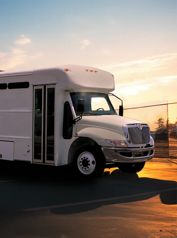 White shuttle bus parked next to a security fence at a prison near Atlanta